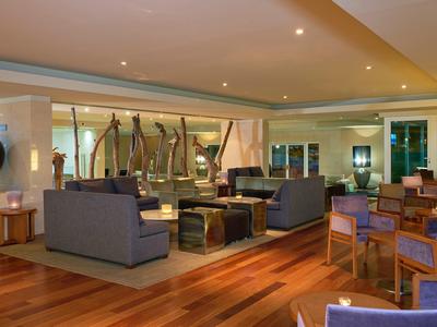 Modern eingerichteter Wohnbereich mit Holzboden, grauen Sofas und großem Fenster zu einer Terrasse.