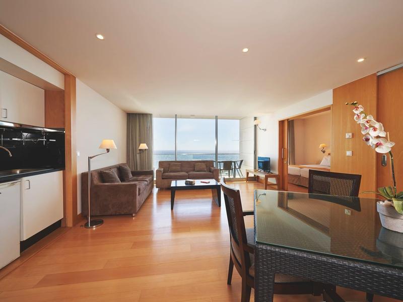 Soggiorno moderno con zona pranzo e grande finestra con vista sul mare.