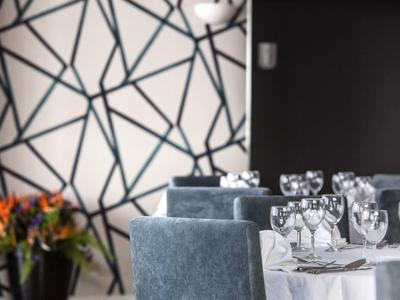 Tavolo da pranzo elegante con bicchieri da vino e centrotavola floreale in una stanza elegante.