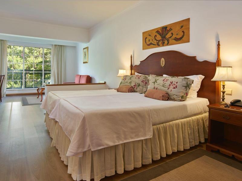 Camera d'hotel accogliente con grande letto matrimoniale e angolo salotto vicino alla finestra