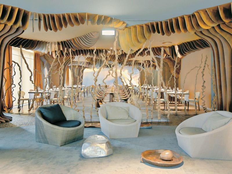 Salon moderne avec éléments en bois courbés et fauteuils confortables.