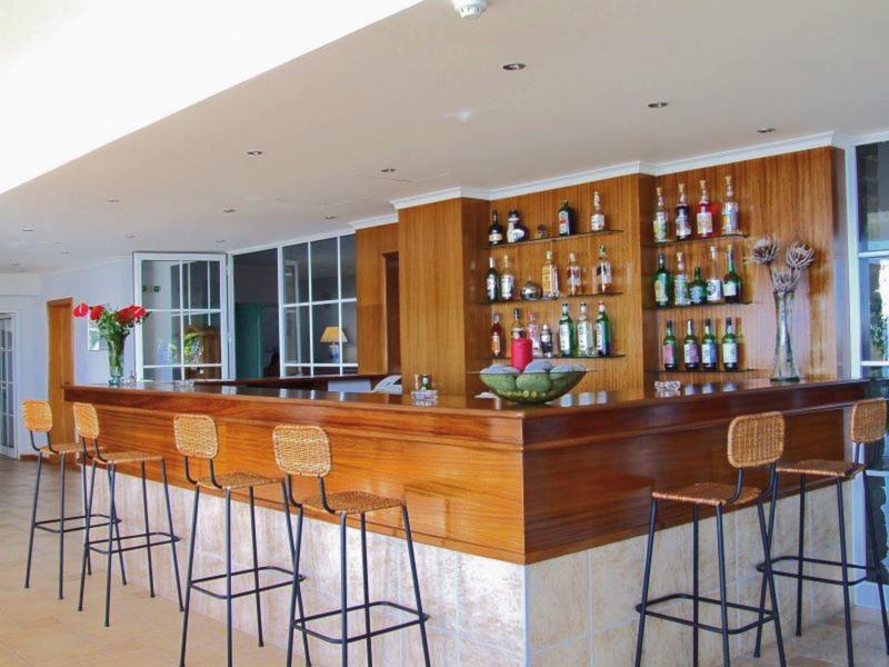 Modern wooden bar area with high stools and decorative elements in a hotel