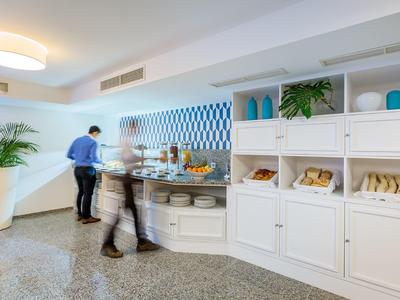 Buffet dell'hotel con pane, pasticceria e ospiti che si servono