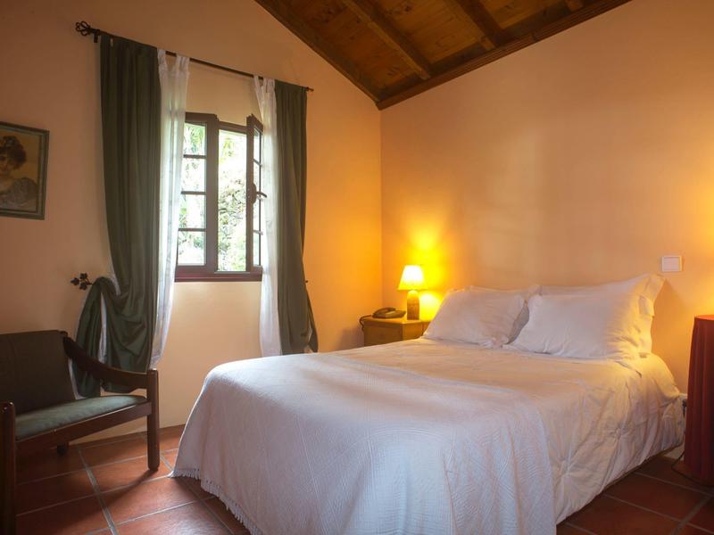 Cozy bedroom with large bed, wooden furniture, and warm lighting in a hotel.