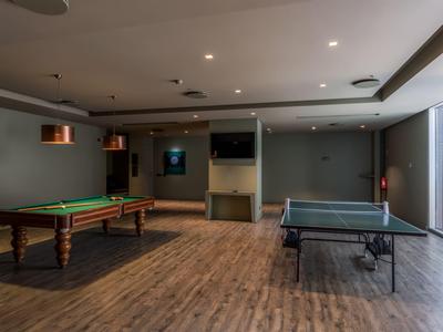 Game room with billiard table and ping pong table on wooden floor in modern room.