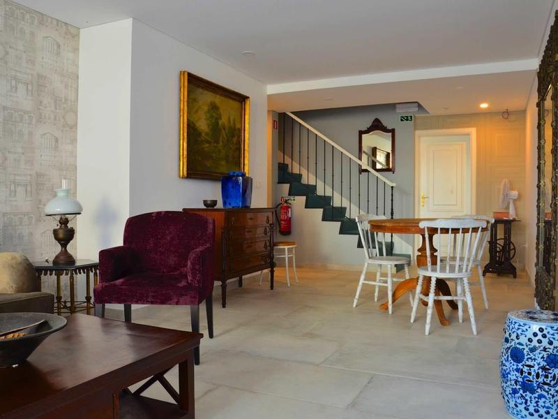 Przytulny salon i jadalnia ze schodami, stołkami barowymi i dekoracjami.