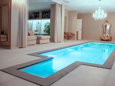 Piscina interior moderna con agua iluminada y ambiente elegante en un hotel.