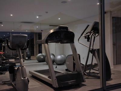 Moderne sportschool met loopband, hometrainers en fitnessballen in een hotel fitnessruimte.