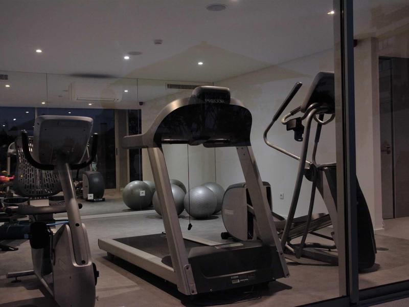 Moderne sportschool met loopband, hometrainers en fitnessballen in een hotel fitnessruimte.