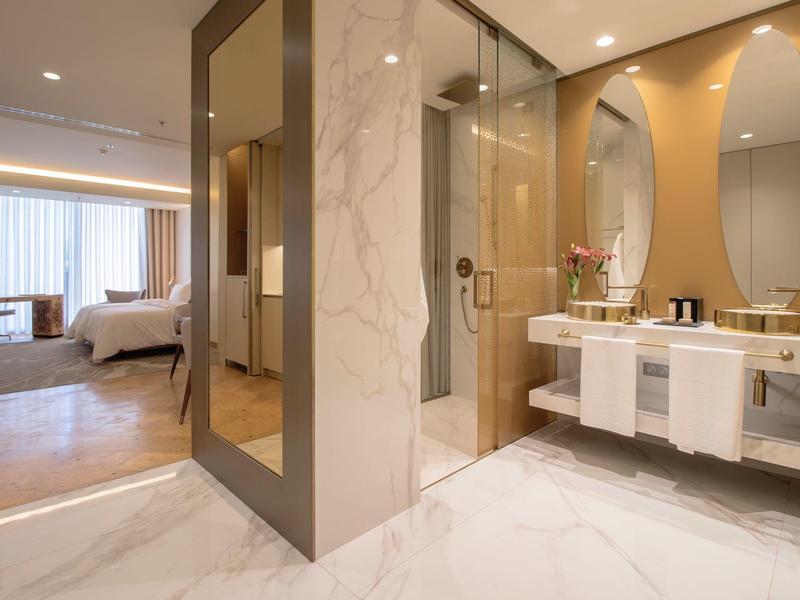 Moderní hotelová koupelna s dvojumyvadlem a přilehlým pokojem