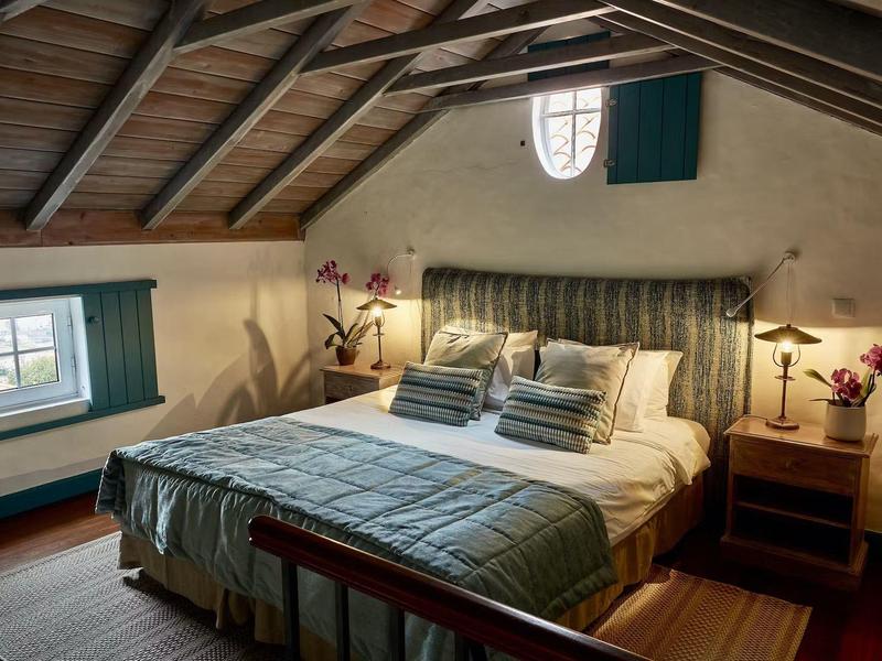 Příjemná ložnice s dřevěným stropem, zelenou postelí a dřevěným nábytkem v rekreačním domě.