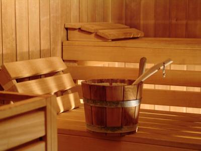 Locale sauna caldo con panche in legno e secchio d'acqua con mestolo.