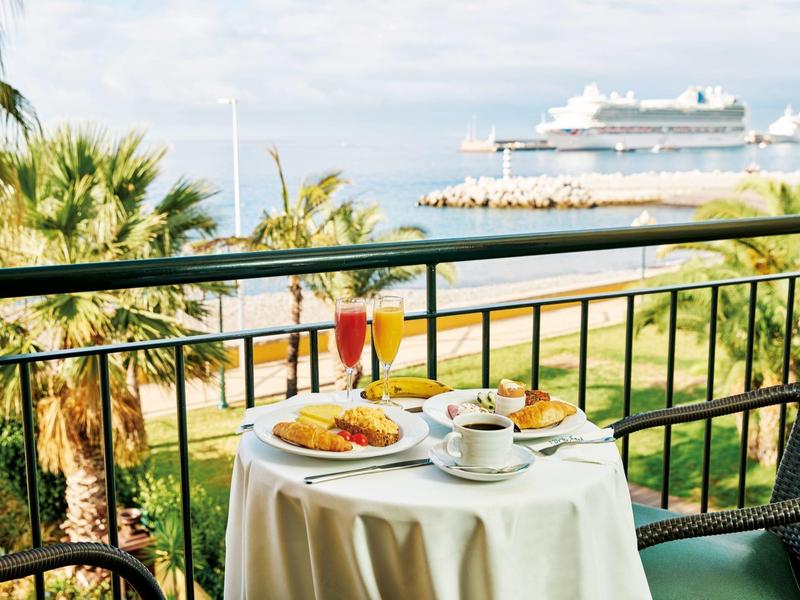 Tavolo sul balcone con colazione vista mare e nave da crociera