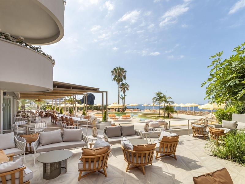 Terrazza luminosa con aree salotto e vista sulla spiaggia e sul mare.