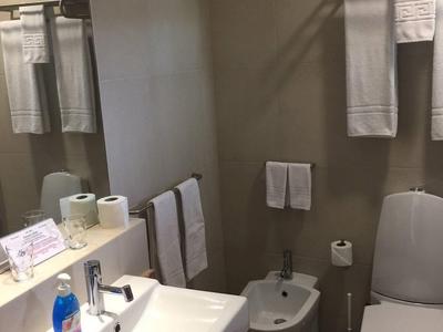 Bagno pulito con lavabo, WC, bidet e asciugamani in una camera d'albergo.