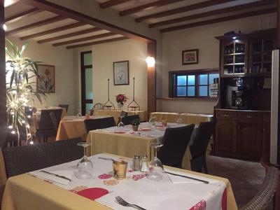 Ristorante accogliente con tavoli apparecchiati, mobili in legno e luce calda.