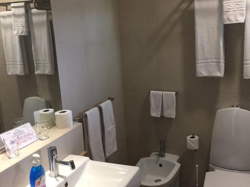 Bagno pulito con lavabo, WC, bidet e asciugamani in una camera d'albergo.