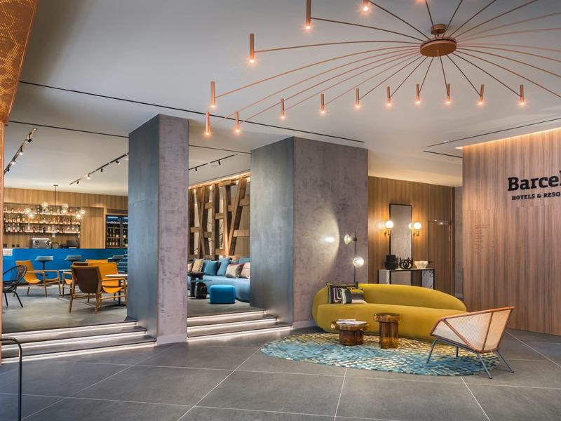 Modern ingerichte hotel lobby met banken, tapijt en verlichting.