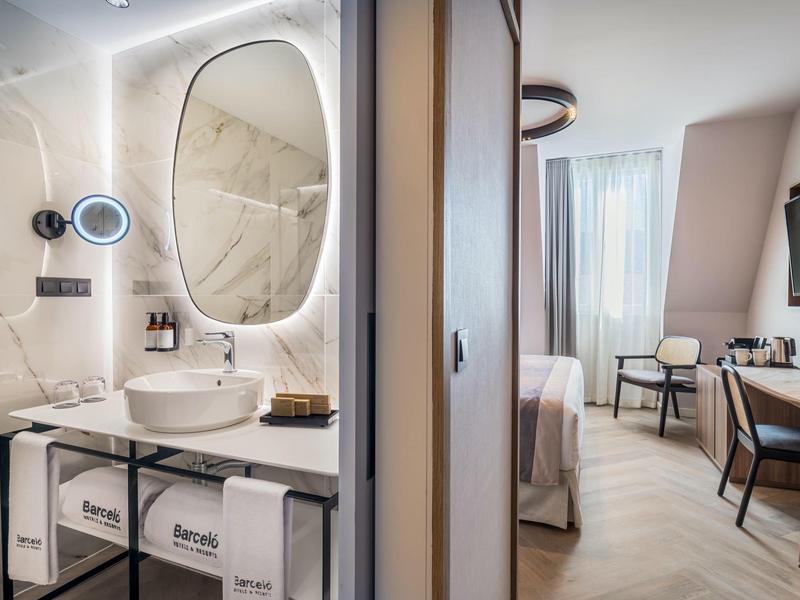 Moderne hotelbadkamer met wastafel en gezellige kamer met bureau en stoelen