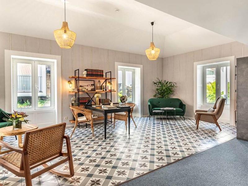 Salon lumineux avec sol à motifs, meubles en bois et cuir, et lampes modernes.