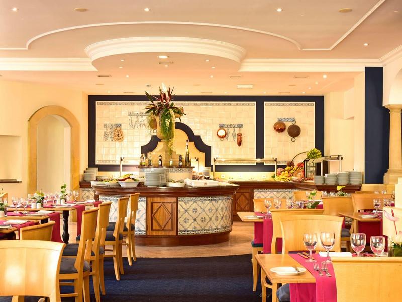 Ristorante elegante con tavoli apparecchiati e decorazione floreale al centro.