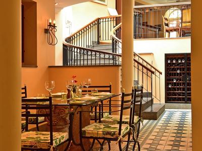 Accogliente zona pranzo con tavolo, sedie e scala in tonalità calde.