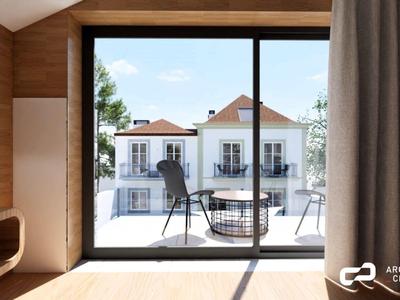 Blick aus einem modernen Holzbungalow auf eine Terrasse mit Stühlen und einem kleinen Tisch.