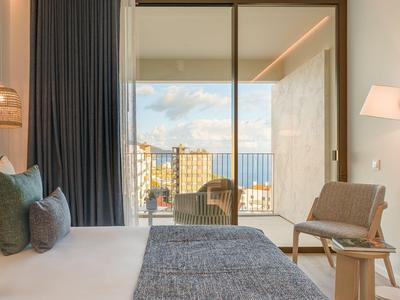 Nowoczesny pokój hotelowy z widokiem na balkon i miasto.