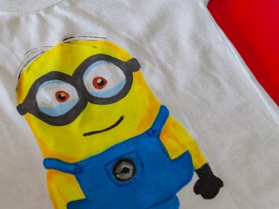Weißes T-Shirt mit aufgedrucktem gelbem Minion in blauer Latzhose auf rotem Hintergrund.