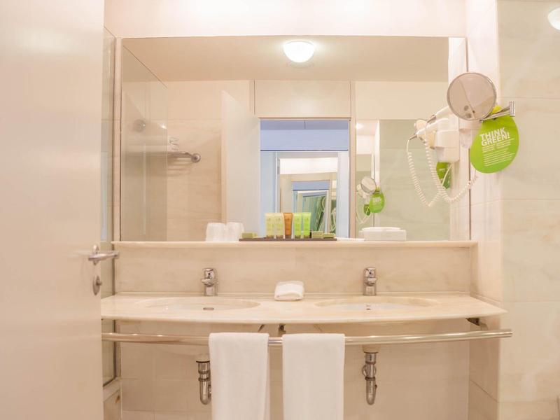 Bagno moderno con doppio lavandino, grandi specchi e asciugamani.