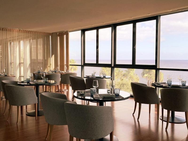 Ristorante luminoso con grandi finestre e posti a sedere con vista sulla natura.