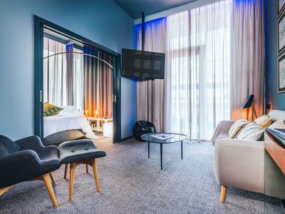 Moderne zitruimte met fauteuils, sofa, tafel en groot raam met gordijnen