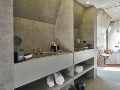 Moderner Badezimmerschrank mit grauen Wänden, integriertem Waschbecken und Handtüchern unten.