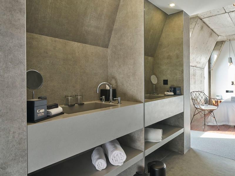 Moderner Badezimmerschrank mit grauen Wänden, integriertem Waschbecken und Handtüchern unten.