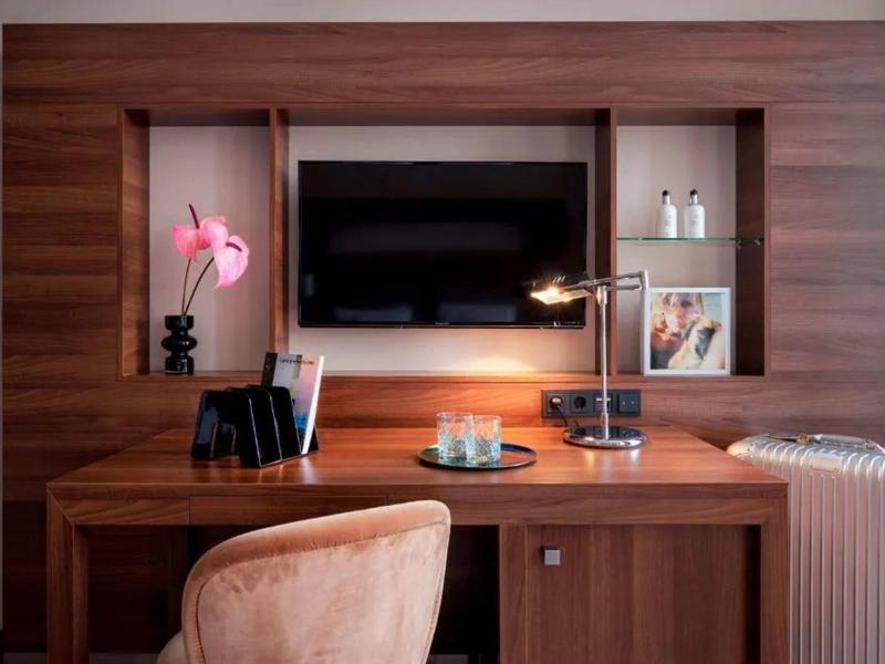 Bureau moderne avec chaise, télévision et décorations en tons chauds de bois.