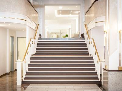 Breite Treppe mit dunklen Stufen und weißen Streifen in einem modernen Innenbereich.