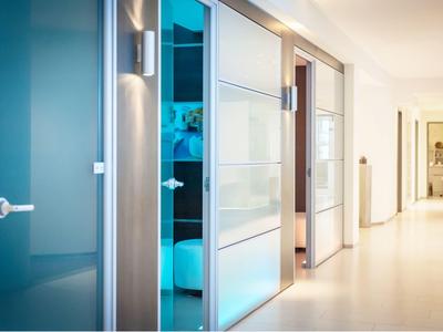 Corridoio con porta moderna e stanza illuminata di blu sullo sfondo in un hotel.