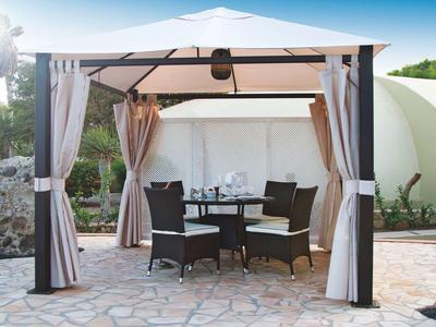 Ein offener Pavillon mit Tisch und vier Stühlen auf einer Steinfläche in sonniger Umgebung