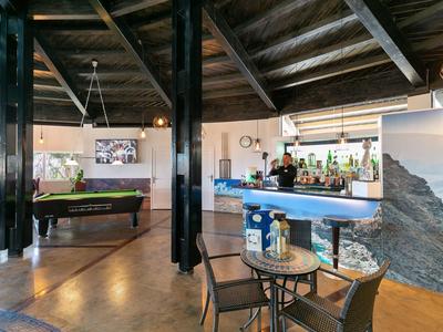 Moderner Barbereich mit Billardtisch, Sitzgelegenheiten und stilvoller Holzkonstruktion im Innenraum.