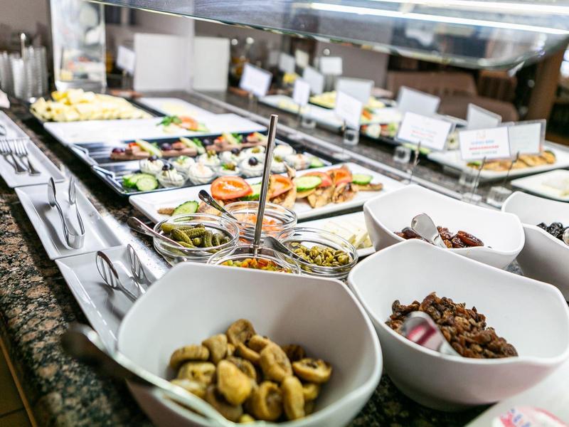 Buffet mit verschiedenen Speisen in weißen Schalen auf einer Granit-Arbeitsplatte.