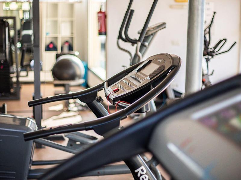 Moderner Fitnessraum mit Laufbändern und verschiedenen Trainingsgeräten.