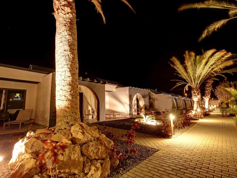 Verlichte wandeling met palmbomen voor een hotel 's nachts