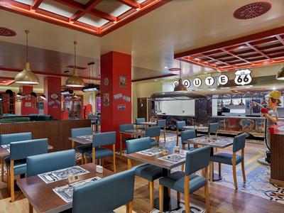 Moderner Dining-Bereich mit blauen Stühlen und Route 66 Schild in einem Hotelrestaurant.