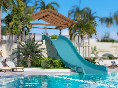 Blauer Wasserrutsche am Hotelpool mit Palmen und Liegestühlen im Hintergrund.