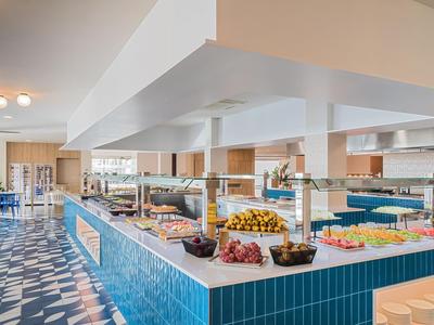 Buffet area with various dishes and blue, white tiles on the buffet.
