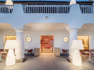 Modern hotel entrance with white columns and warm lighting.