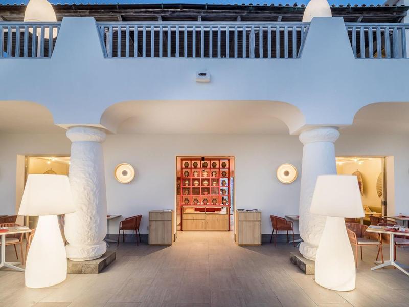 Modern hotel entrance with white columns and warm lighting.