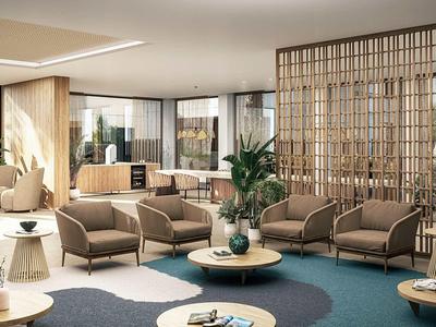 Modernes Wohnzimmer mit beigen Sesseln, runden Tischen, blauem Teppich und Holzwänden.