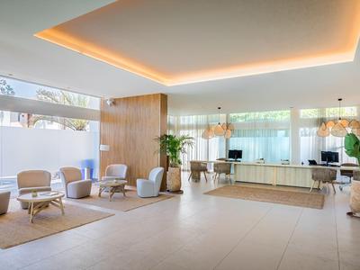 Helle, moderne Hotellobby mit Sitzbereichen und Empfangstresen.