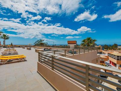 Terrazza sul tetto con lettini, vista su edifici e cielo nuvoloso